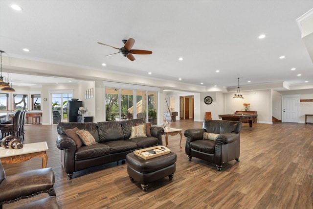 living room featuring baseboards, ceiling fan, wood finished floors, crown molding, and recessed lighting