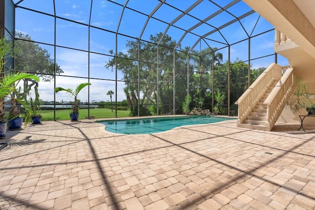 outdoor pool with a patio, stairway, and a lanai