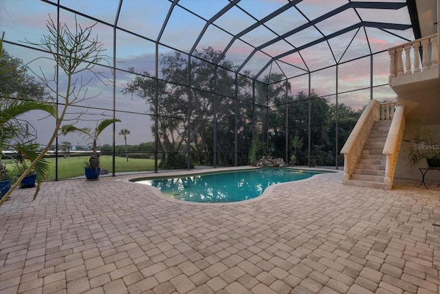 pool at dusk featuring stairs, glass enclosure, and a patio