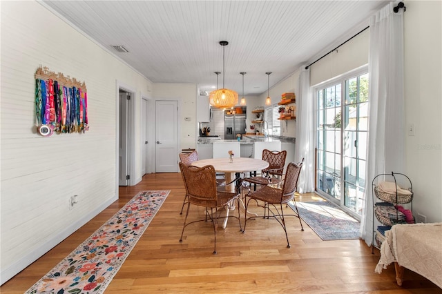 dining space featuring light wood-type flooring and visible vents