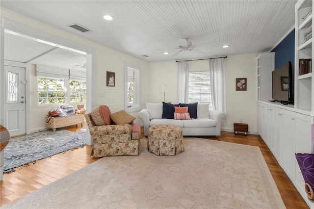 living area with a ceiling fan, recessed lighting, visible vents, and wood finished floors