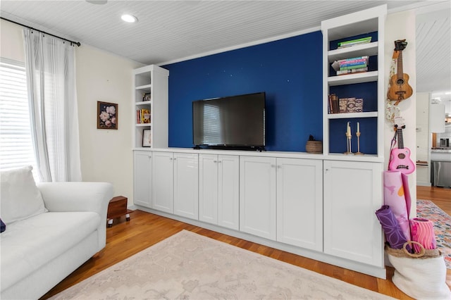 living room featuring built in features, light wood-type flooring, and recessed lighting