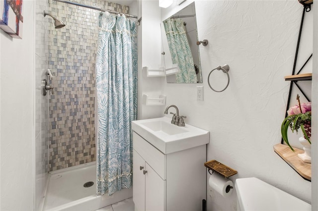 bathroom with toilet, a shower stall, and vanity