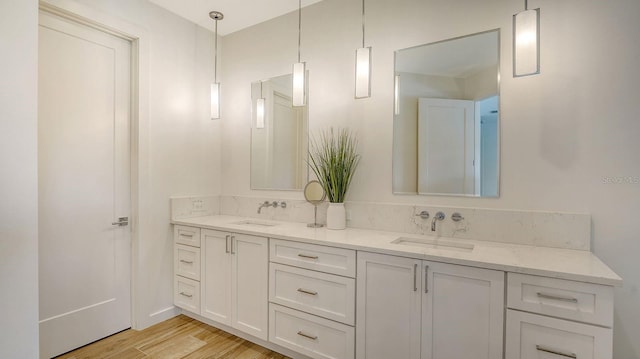 full bath with a sink, wood finished floors, and double vanity
