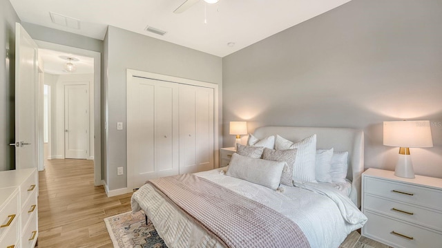 bedroom featuring a closet, visible vents, baseboards, and light wood-style floors