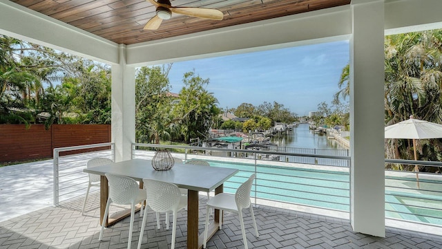 exterior space with ceiling fan, a water view, and wooden ceiling