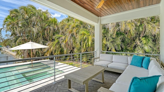 view of patio featuring a balcony, ceiling fan, and outdoor lounge area