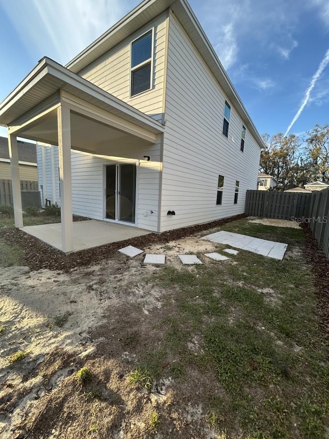 rear view of property featuring a patio area and fence