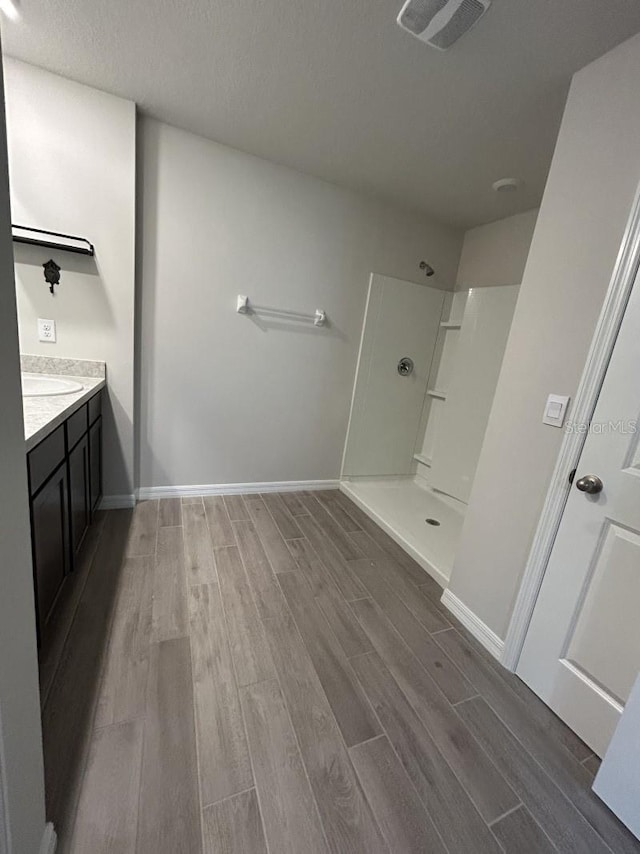 13633 NW 14th Pl, Newberry, FL 32669 - bathroom featuring baseboards, visible vents, a walk in shower, and wood finish floors