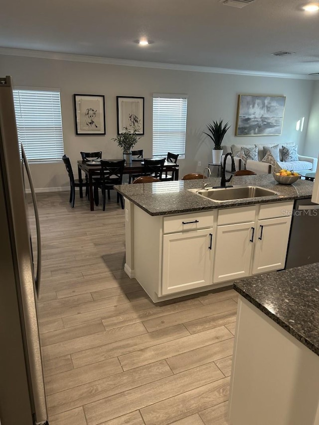 13633 NW 14th Pl, Newberry, FL 32669 - kitchen with light wood finished floors, ornamental molding, a sink, and freestanding refrigerator