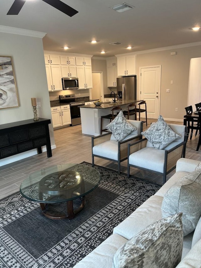 13633 NW 14th Pl, Newberry, FL 32669 - living room with recessed lighting, visible vents, ornamental molding, light wood-type flooring, and baseboards