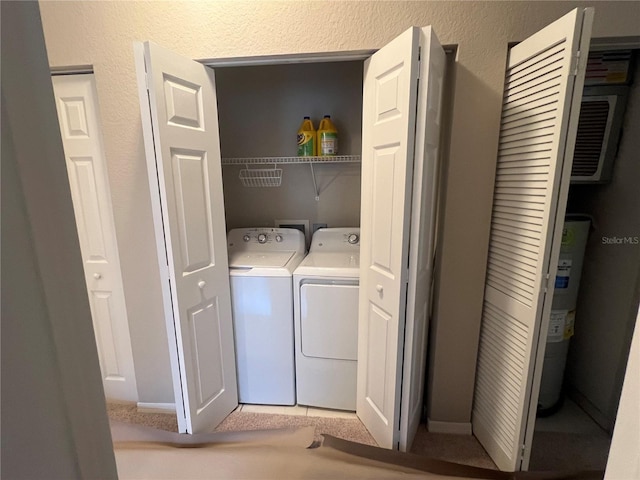 clothes washing area featuring a textured wall, laundry area, and washing machine and clothes dryer