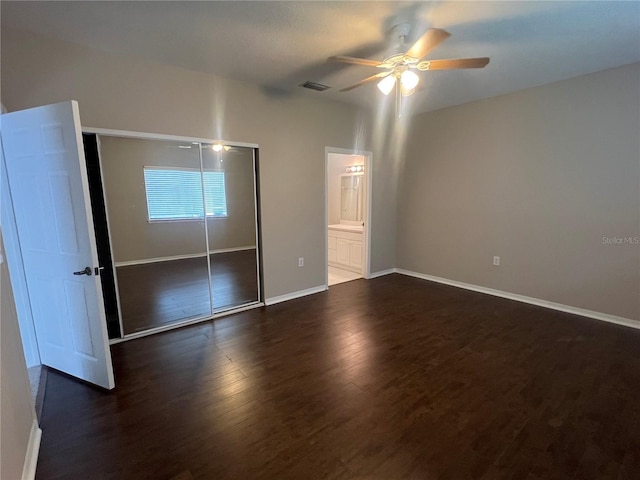 unfurnished bedroom featuring a closet, visible vents, a ceiling fan, wood finished floors, and baseboards