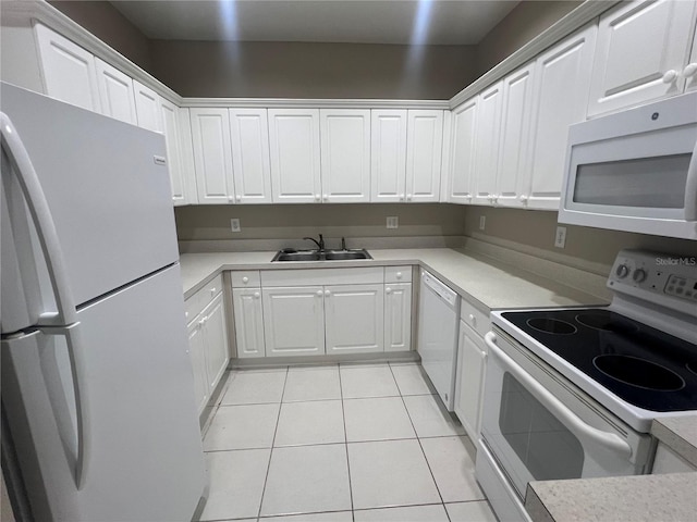 kitchen featuring white appliances, light tile patterned flooring, a sink, and white cabinetry