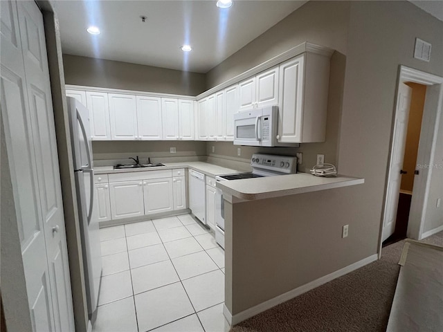 kitchen featuring light tile patterned floors, white appliances, a sink, visible vents, and light countertops