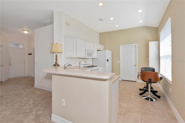 kitchen with white appliances, light tile patterned floors, a peninsula, light countertops, and a sink