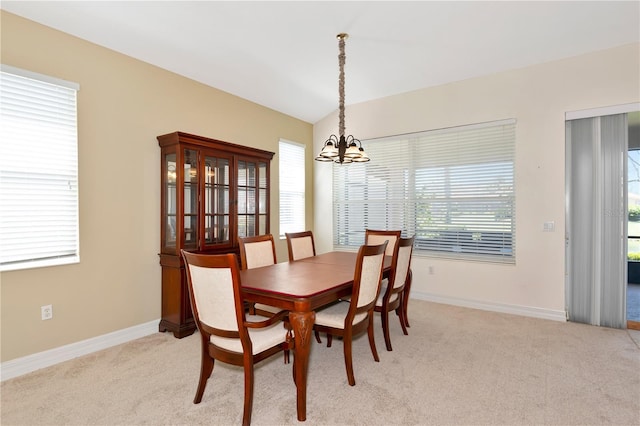 dining area with a healthy amount of sunlight, a notable chandelier, and light colored carpet