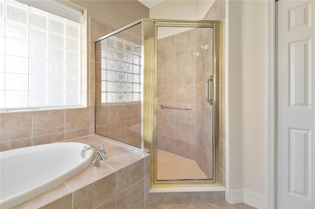 full bathroom featuring a stall shower, tile patterned flooring, and a garden tub