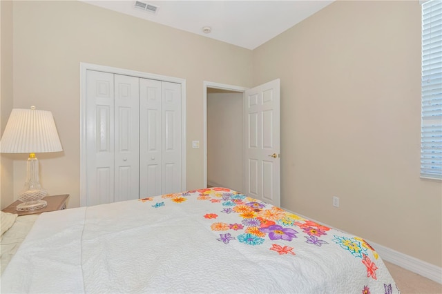 carpeted bedroom featuring multiple windows, a closet, visible vents, and baseboards