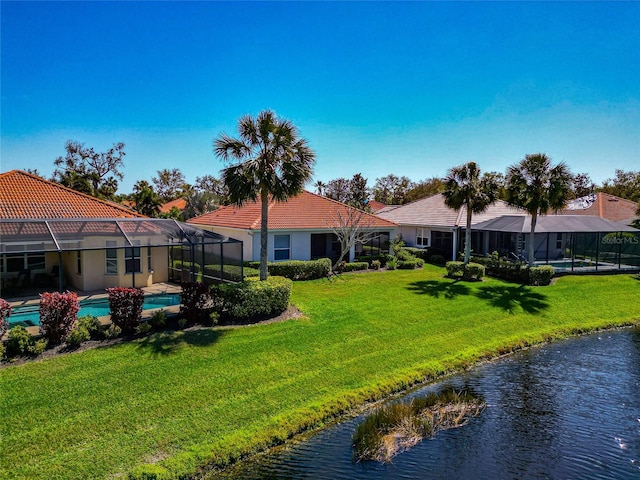 back of property featuring an outdoor pool, a tile roof, a lanai, a yard, and stucco siding