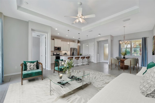 3838 Manorwood Loop, Parrish, FL 34219 - living room with crown molding, a raised ceiling, ceiling fan with notable chandelier, baseboards, and light tile patterned floors