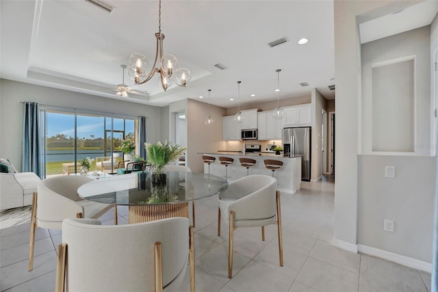 3838 Manorwood Loop, Parrish, FL 34219 - dining area featuring visible vents, a raised ceiling, a water view, and baseboards