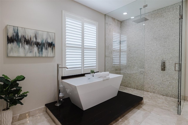 bathroom with recessed lighting, a walk in shower, and a freestanding bath