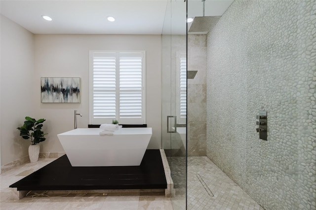 bathroom featuring recessed lighting, tiled shower, and a freestanding bath