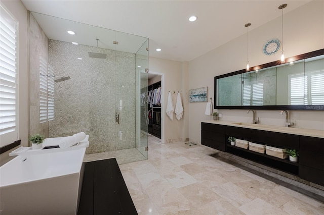 full bathroom featuring a freestanding tub, a walk in closet, a tile shower, recessed lighting, and vanity