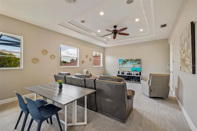 interior space with visible vents, plenty of natural light, a raised ceiling, and ceiling fan