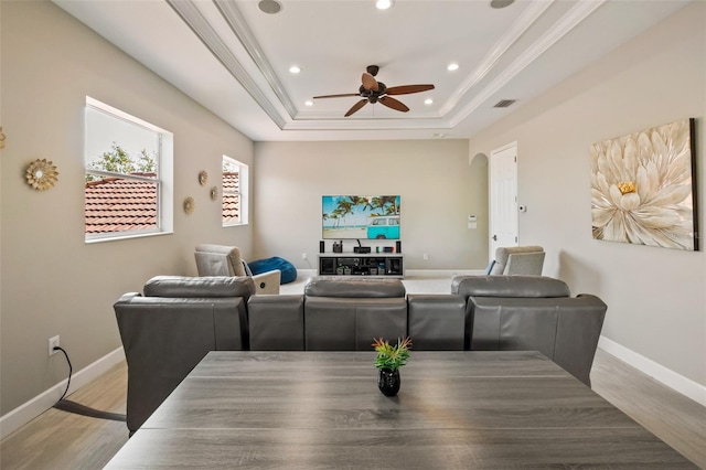 cinema room featuring visible vents, ceiling fan, baseboards, and a tray ceiling