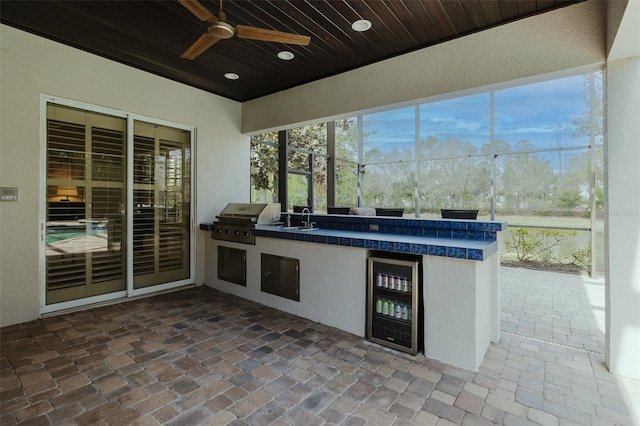 view of patio / terrace with area for grilling, a sink, grilling area, wine cooler, and ceiling fan