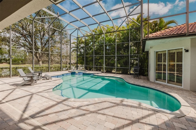 view of swimming pool featuring a patio area, a pool with connected hot tub, and a lanai