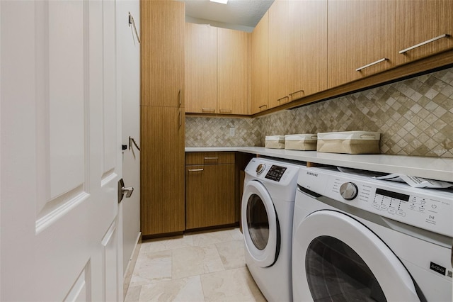 laundry room with washer and clothes dryer, cabinet space, and stone finish flooring