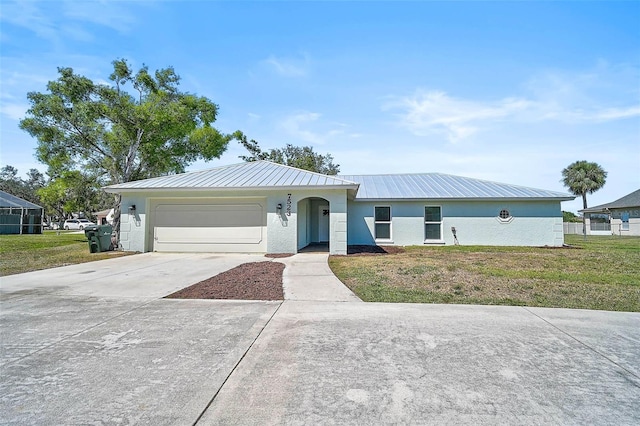 single story home with an attached garage, metal roof, driveway, and stucco siding