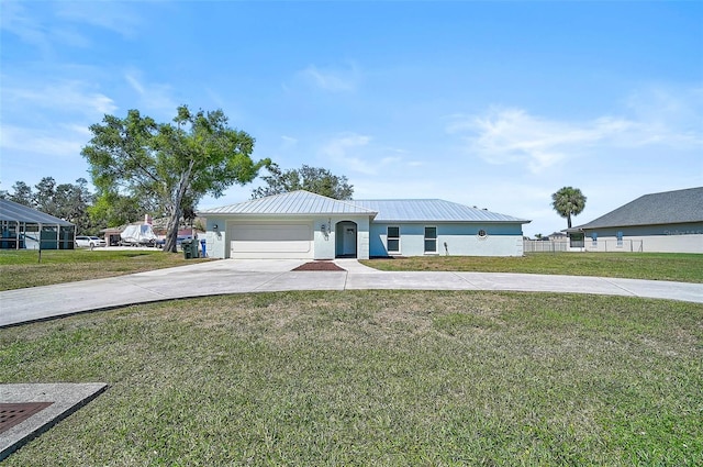 view of front of home featuring stucco siding, driveway, metal roof, a front yard, and a garage