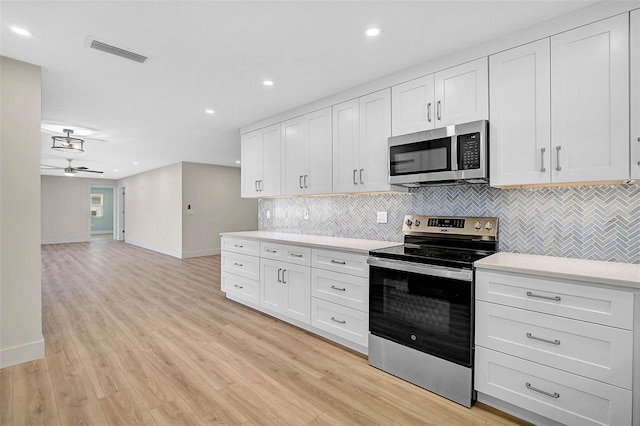 kitchen featuring light wood finished floors, visible vents, light countertops, appliances with stainless steel finishes, and white cabinets