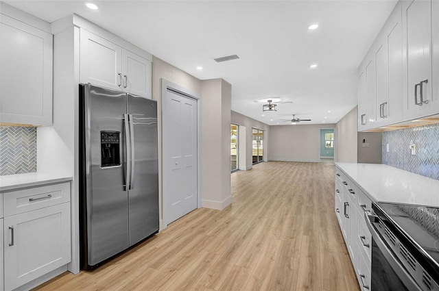 kitchen with light countertops, white cabinets, visible vents, and stainless steel fridge