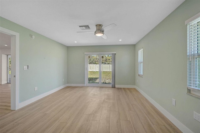 spare room with visible vents, light wood-style flooring, baseboards, and ceiling fan