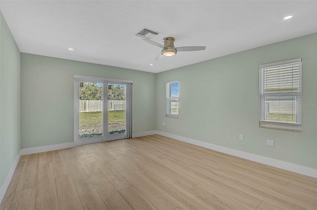 empty room featuring visible vents, ceiling fan, baseboards, and wood finished floors