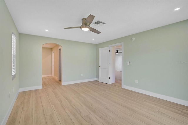 spare room featuring visible vents, recessed lighting, arched walkways, light wood finished floors, and baseboards