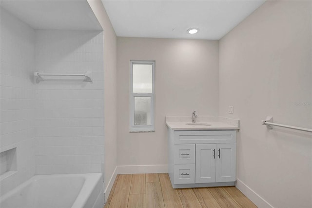 full bathroom featuring bathtub / shower combination, vanity, baseboards, and wood finished floors