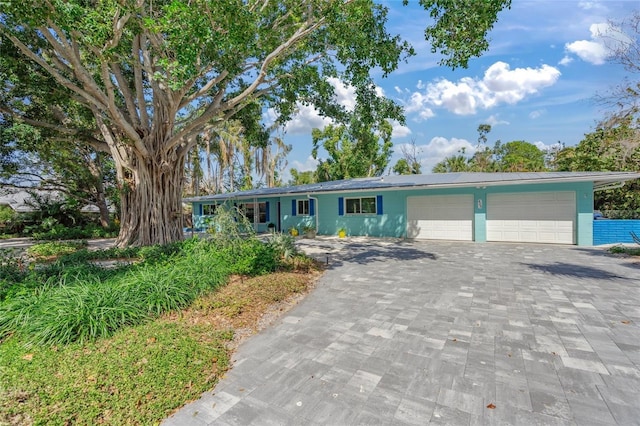 single story home with a garage and decorative driveway