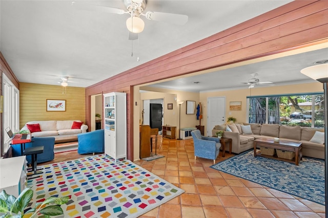 living area featuring wooden walls and a ceiling fan