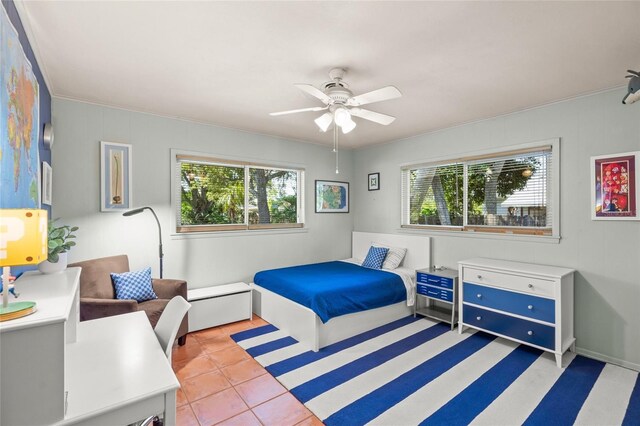 bedroom featuring tile patterned flooring, multiple windows, and a ceiling fan