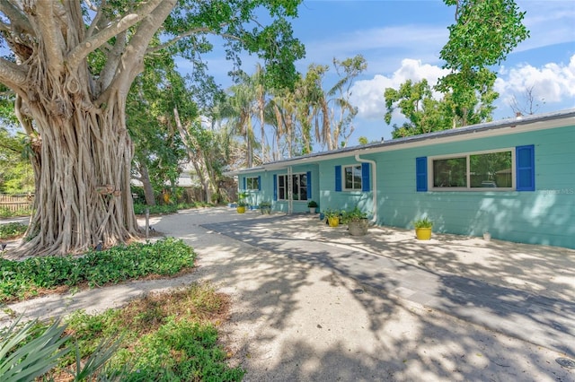 ranch-style home featuring driveway and concrete block siding