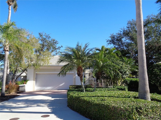 view of front of property featuring a garage, driveway, and stucco siding