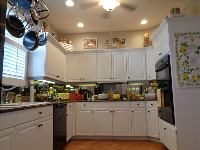 1354 Tearose Pl, Sarasota, FL 34239 - kitchen with black appliances, a sink, dark countertops, white cabinetry, and recessed lighting