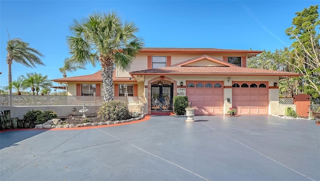 view of front of property featuring a garage, driveway, fence, and french doors