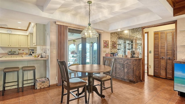 dining area with light tile patterned floors, a toaster, baseboards, a raised ceiling, and french doors